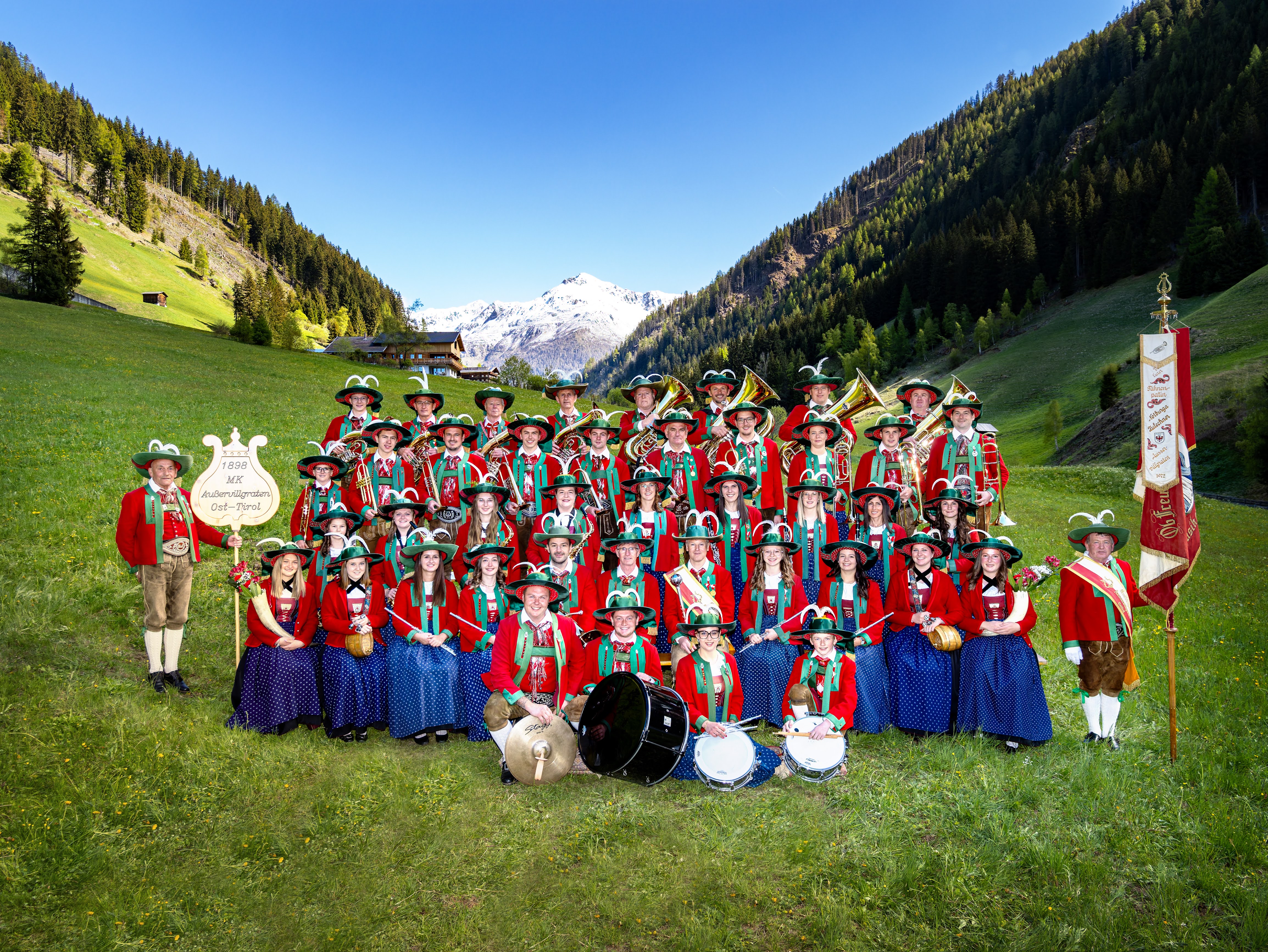 Gruppenfoto der Musikkapelle Außervillgraten in Tracht auf Wiese